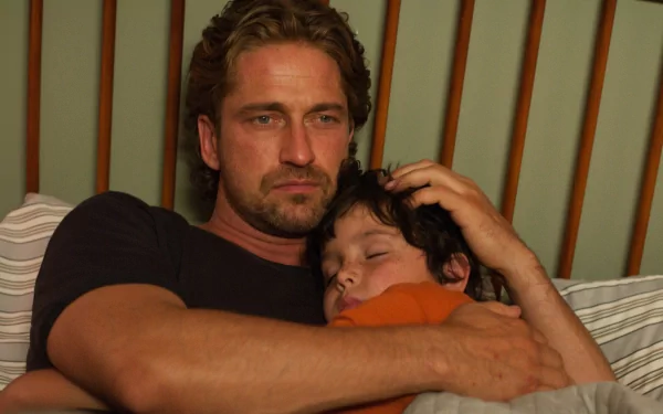 Man from the movie Playing for Keeps cradling a sleeping child in a tender father moment — 4K Ultra HD PC desktop wallpaper/background.