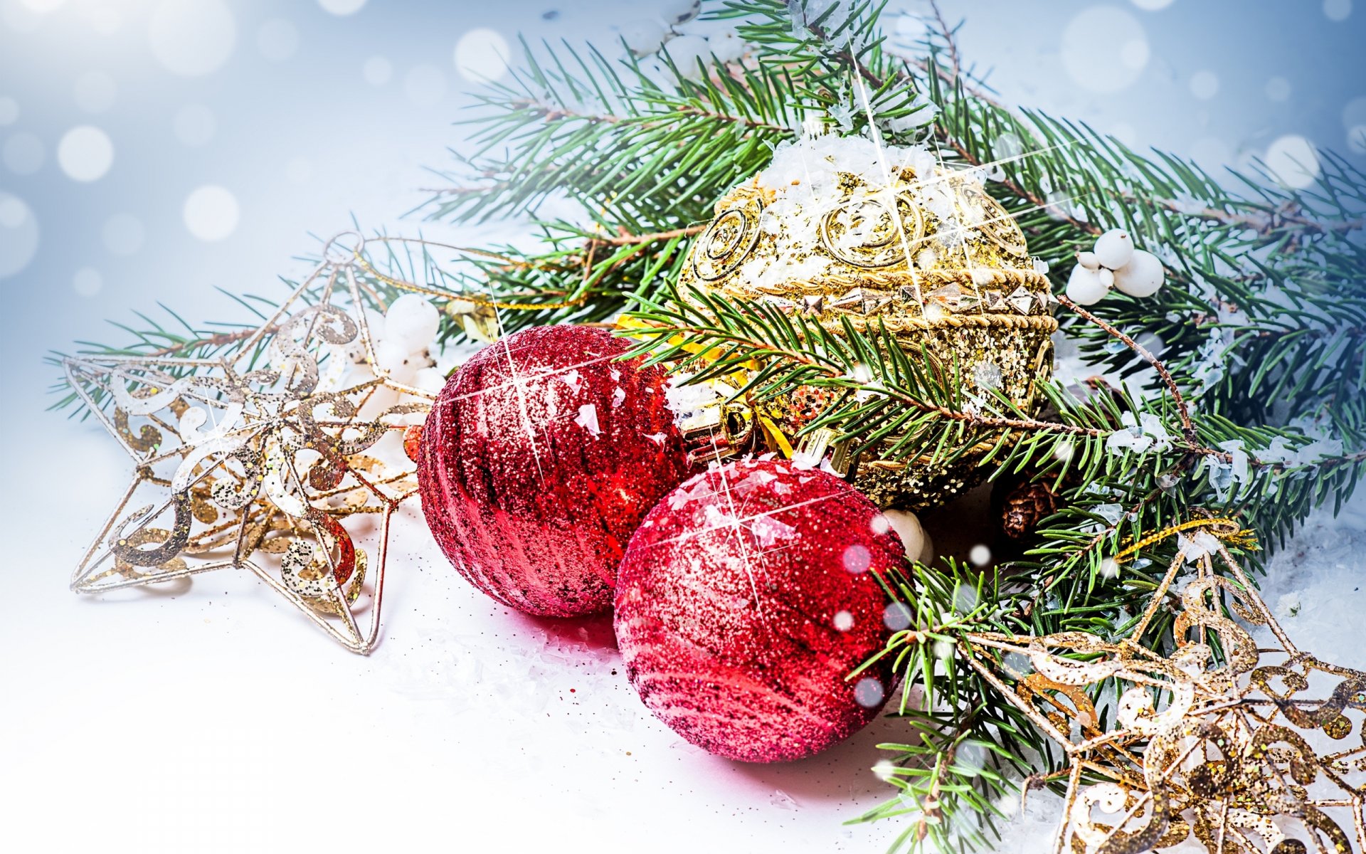 HD PC desktop wallpaper featuring festive Christmas ornaments, including red and gold baubles, gold stars, and evergreen branches dusted with snow for a holiday-themed background.