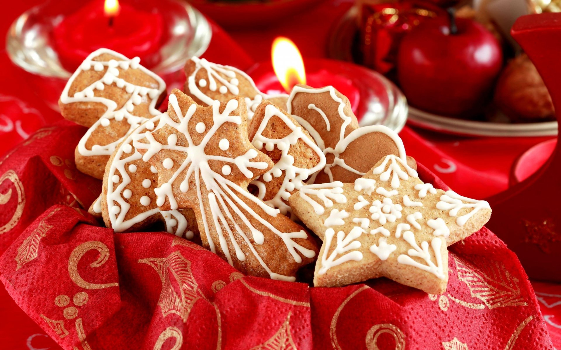 HD PC desktop wallpaper featuring festive Christmas gingerbread cookies with intricate white icing, surrounded by red candles and holiday decorations.