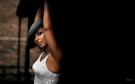 HD desktop wallpaper featuring Alicia Keys in a close-up pose, highlighting her expressive gaze and stylish hat against a dimly lit background.