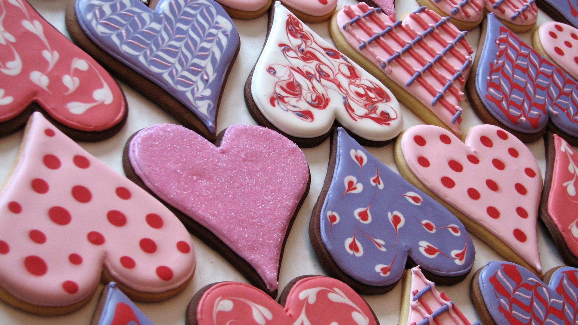HD PC desktop wallpaper featuring an array of heart-shaped cookies decorated with pink, red, and purple icing in various patterns.
