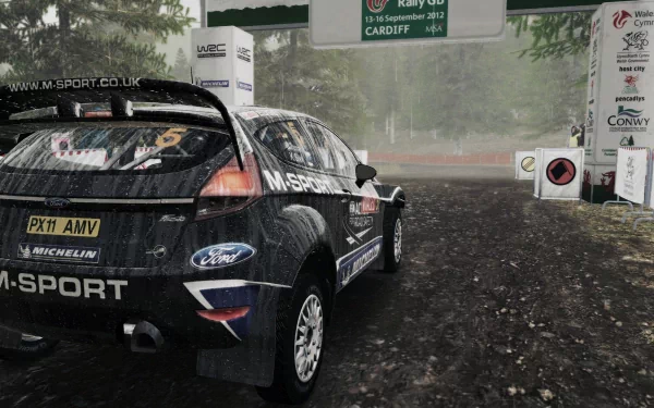 HD desktop wallpaper featuring a Ford rally car from WRC 3 on a muddy course, with background signage and trees enveloped in mist.