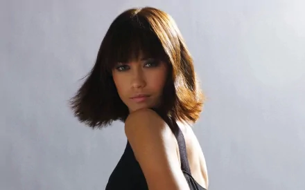 HD PC desktop wallpaper featuring celebrity Olga Kurylenko with a sleek bob haircut, wearing a black outfit against a neutral background.