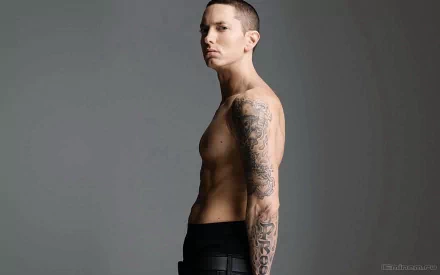 A high-definition desktop wallpaper featuring Eminem, showcasing his side profile with visible tattoos against a neutral background.