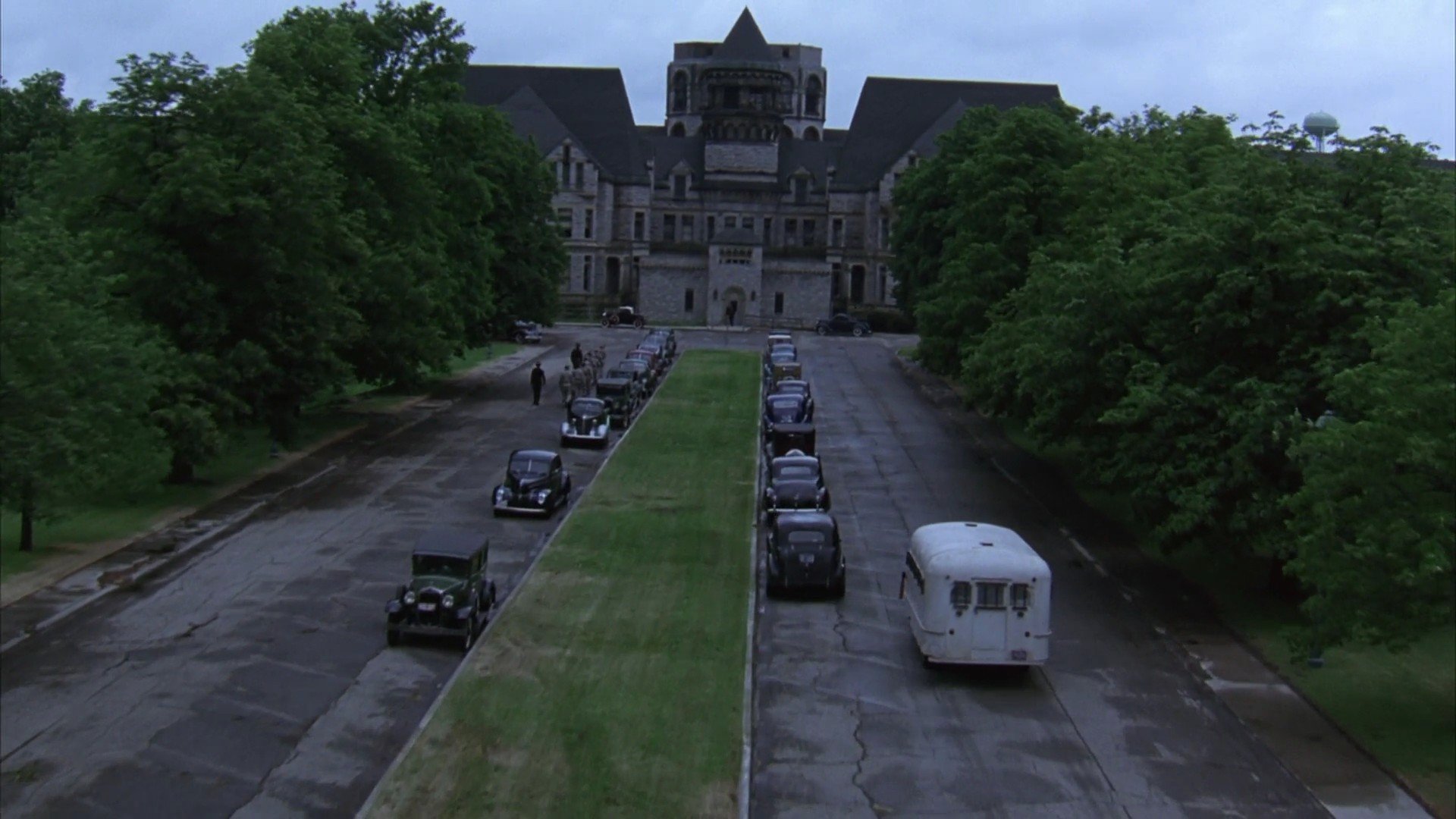 HD wallpaper based on The Shawshank Redemption, featuring the prison exterior with vehicles aligned on the driveway.