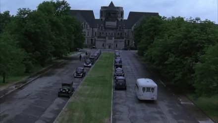 HD wallpaper based on The Shawshank Redemption, featuring the prison exterior with vehicles aligned on the driveway.