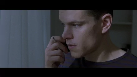 HD desktop wallpaper featuring a scene from The Bourne Identity with a focused individual on the phone.