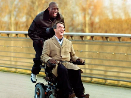 HD desktop wallpaper featuring two men, one pushing the other in a wheelchair, both with joyful expressions, from Intouchables.