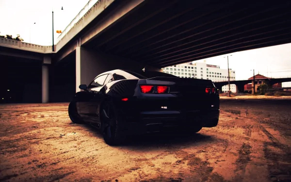 HD wallpaper of a Chevrolet Camaro parked under a bridge, showcasing its sleek black design as a striking desktop background.