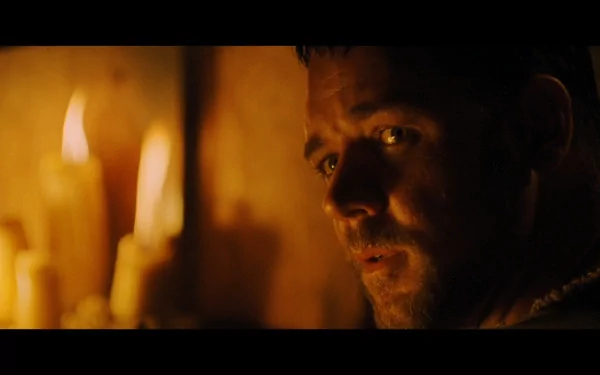 HD desktop wallpaper and background featuring a scene from the movie Gladiator, with a close-up of a determined man lit by flickering candles.