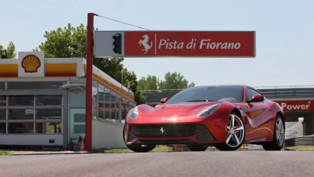 A red Ferrari F12berlinetta parked at the Fiorano Circuit, serving as a sleek HD desktop wallpaper.