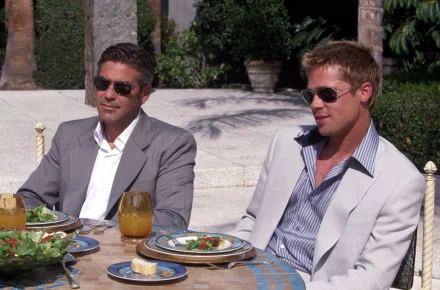 HD wallpaper featuring George Clooney and Brad Pitt from Ocean's Eleven, seated and dining outdoors.