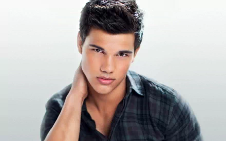 A high-definition desktop wallpaper featuring celebrity Taylor Lautner, showcasing a close-up of his striking expression against a soft, light background.