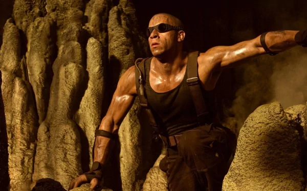 HD PC desktop wallpaper featuring celebrity Vin Diesel in an action pose, wearing sunglasses and tactical gear against a rugged, rocky background.