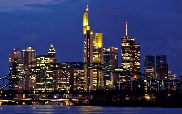 Frankfurt, Germany skyline at dusk with illuminated skyscrapers and bridge over the Main — man-made cityscape, 2K Quad HD PC desktop wallpaper.