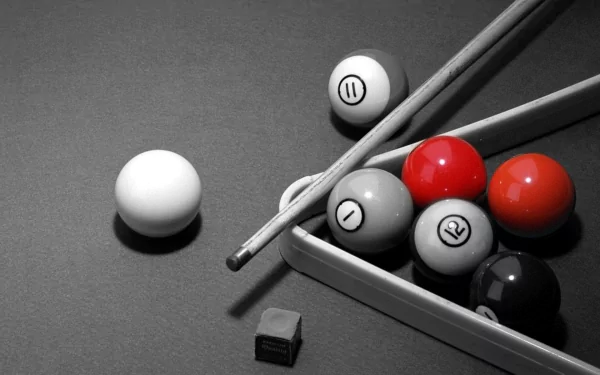 HD desktop wallpaper featuring a close-up of a man-made pool game setup with balls, cues, and chalk on a textured surface in black, white, and red tones.