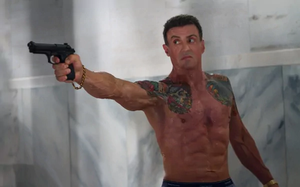 Shirtless tattooed man aiming a handgun in a tense scene from Bullet to the Head — 2K Quad HD PC desktop wallpaper and background.