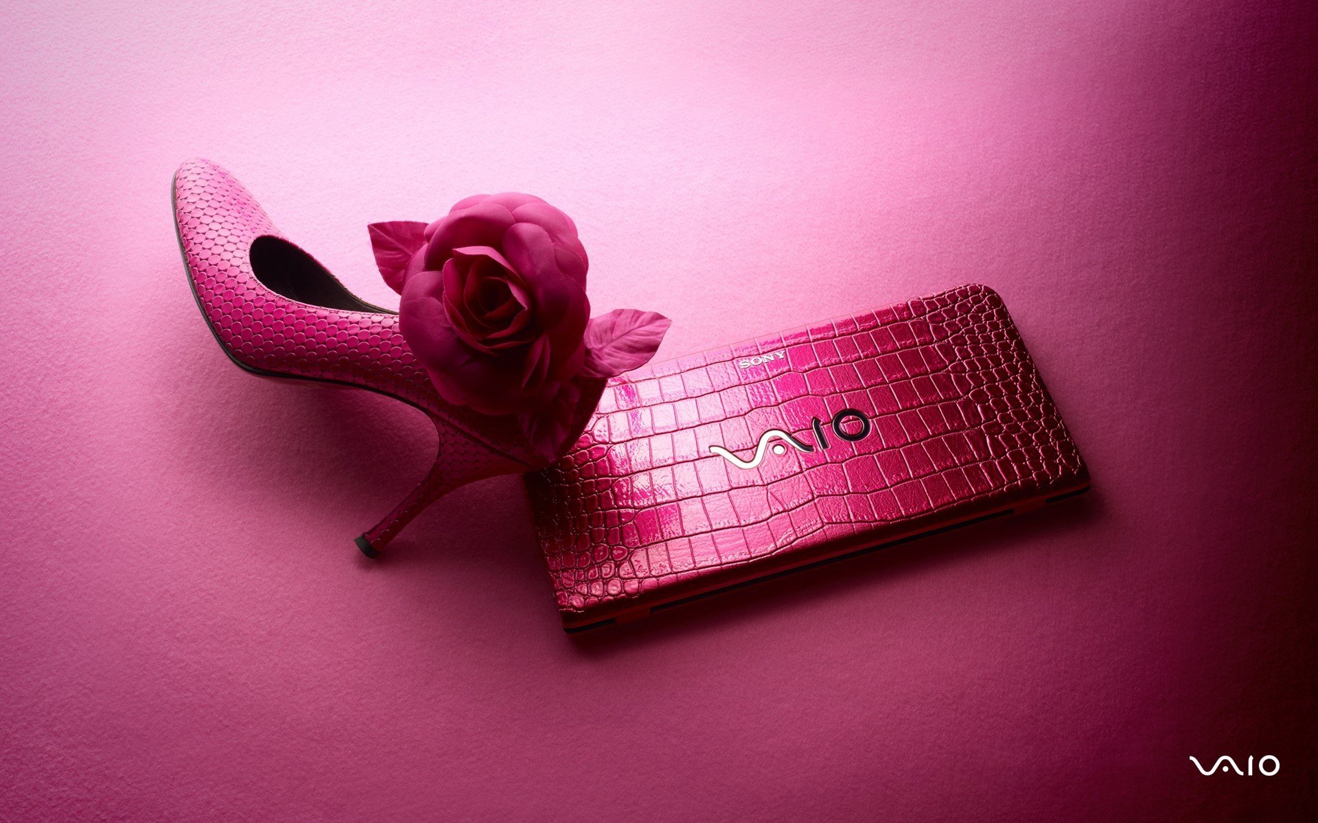 HD PC desktop wallpaper featuring a pink Sony Vaio laptop with a textured pattern and a matching pink high-heeled shoe adorned with a rose, set against a pink background.