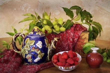 HD desktop wallpaper still life: ornate blue teapot, bowl of ripe raspberries, small red vase and leafy branches arranged on a patterned cloth.