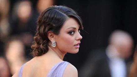 A stunning HD desktop wallpaper featuring celebrity Mila Kunis, elegantly styled with soft curls and adorned with statement earrings, exuding grace and allure.