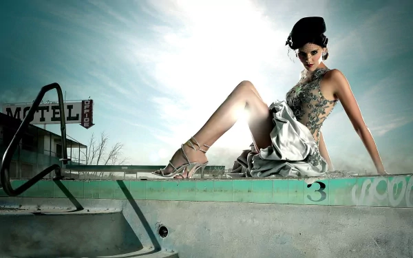 A striking HD wallpaper featuring Maggie Grace, showcasing her elegance as she poses by an abandoned motel pool under a dramatic sky.