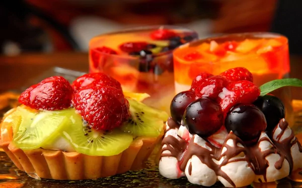 A vibrant display of desserts featuring fruit tarts and jellies, showcasing rich colors and textures. This 4K Ultra HD image serves as an appealing food-themed desktop wallpaper.