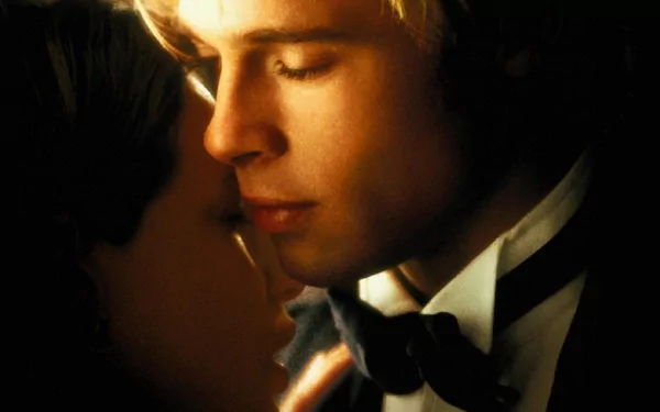 Romantic golden-lit movie still: blond man in a tuxedo and woman nearly kissing in an intimate close-up — HD PC desktop wallpaper/background.