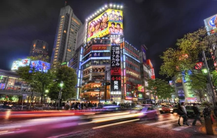 A vibrant Tokyo street scene captured at night, showcasing illuminated billboards and a bustling crowd, with a dynamic time-lapse effect highlighting the city's energy.
