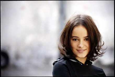 HD desktop wallpaper featuring Alizée with a soft-focus background, capturing a serene and confident expression linked to music.