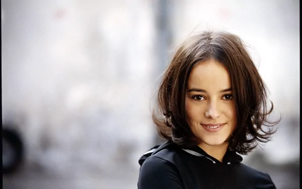 HD desktop wallpaper featuring Alizée with a soft-focus background, capturing a serene and confident expression linked to music.
