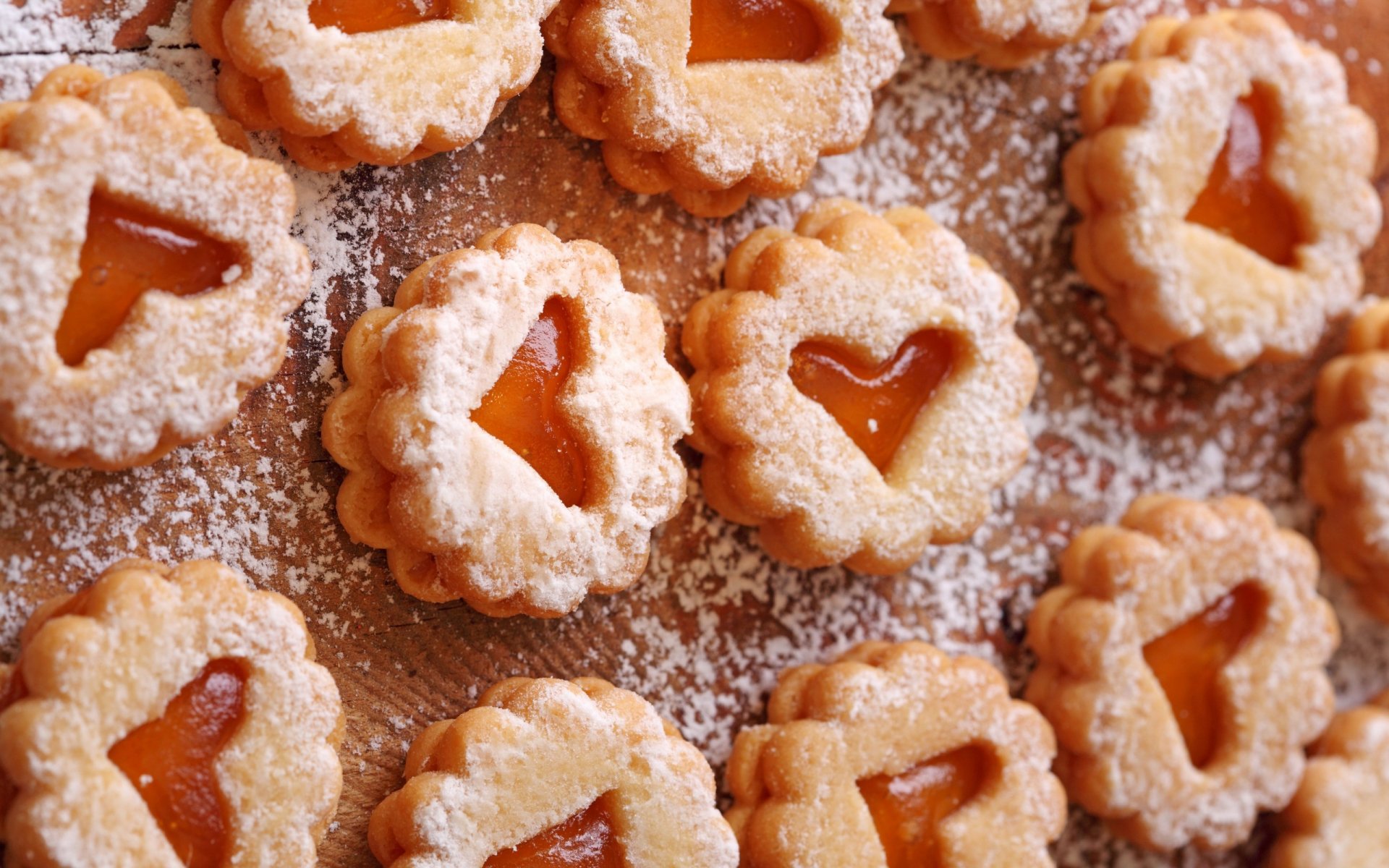 HD PC desktop wallpaper featuring heart-shaped cookies dusted with powdered sugar, arranged on a wooden surface.