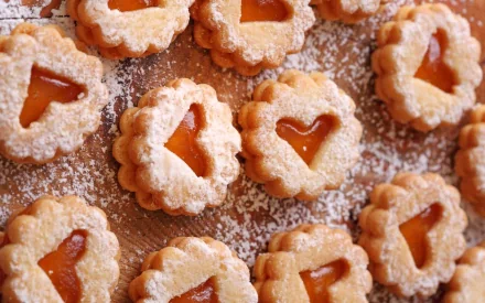 HD PC desktop wallpaper featuring heart-shaped cookies dusted with powdered sugar, arranged on a wooden surface.