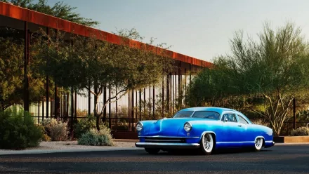 Blue 1951 Kaiser Dragon Coupe vehicle parked beside desert shrubs under a modern canopy - HD PC desktop wallpaper/background.