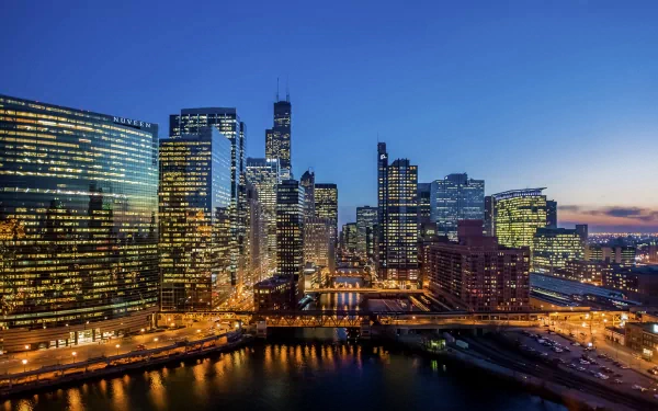 HD desktop wallpaper showcasing Chicago’s man-made skyline at twilight with illuminated skyscrapers and the river reflecting city lights.