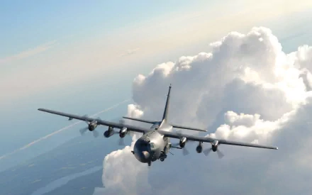 HD desktop wallpaper showing a Lockheed AC-130 military aircraft flying near clouds in a clear sky.