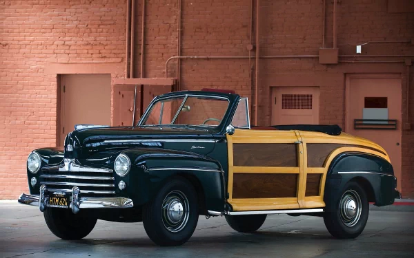 HD PC desktop wallpaper/background of a dark blue 1946 Ford Super Deluxe woody convertible vehicle parked against a brick wall.