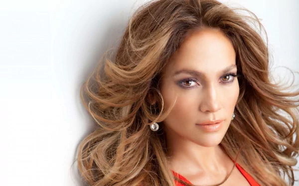 HD PC desktop wallpaper featuring a close-up portrait of celebrity Jennifer Lopez with flowing hair and a confident expression.