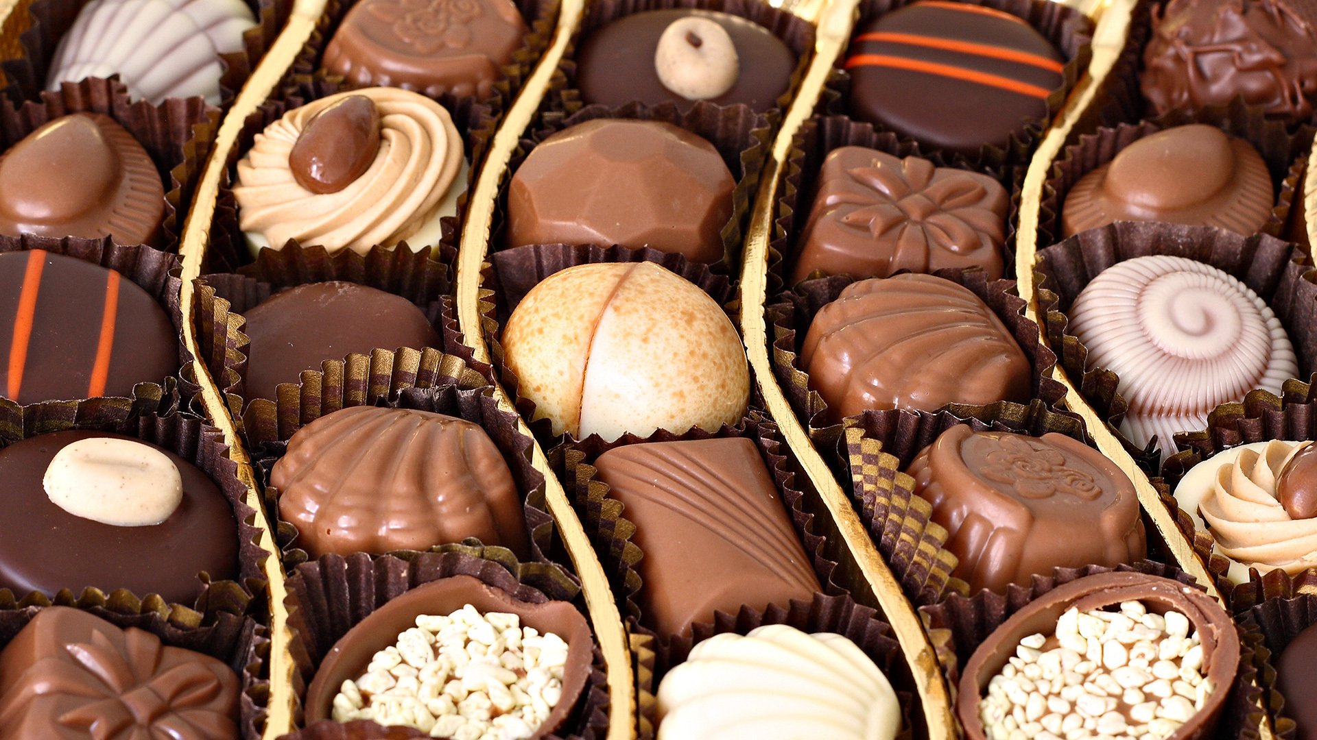 HD PC desktop wallpaper featuring an assortment of rich, detailed chocolates arranged in neat rows, showcasing various shapes and textures.