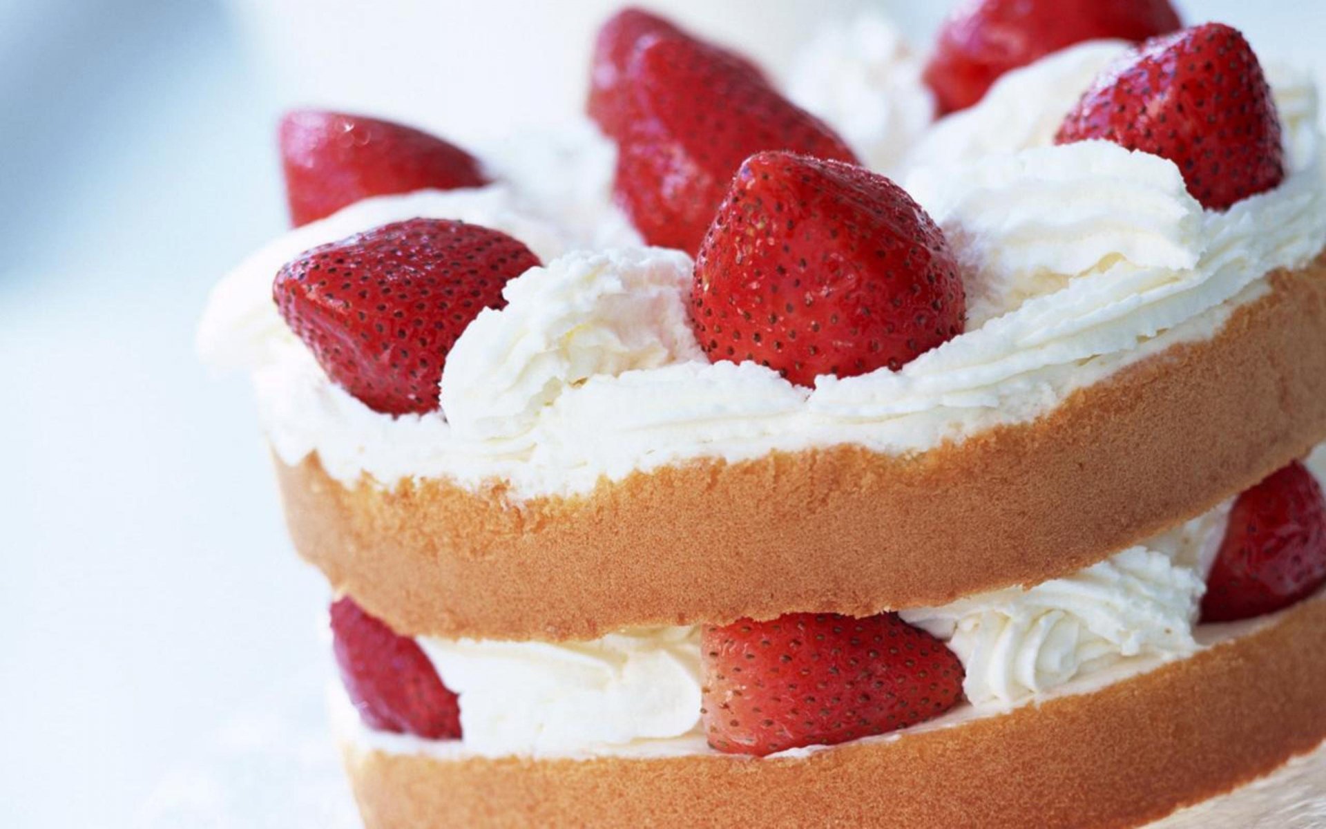 HD desktop wallpaper featuring a delicious strawberry shortcake with layers of sponge cake, whipped cream, and fresh strawberries.