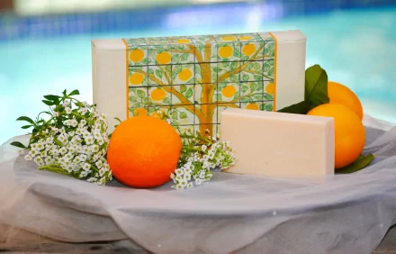 HD desktop wallpaper featuring man-made spa soap bars, fresh oranges, and delicate white flowers arranged by a poolside.