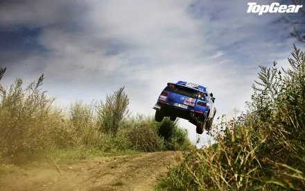 HD Top Gear desktop wallpaper featuring a rally car mid-jump on a dirt track with the show's logo visible.