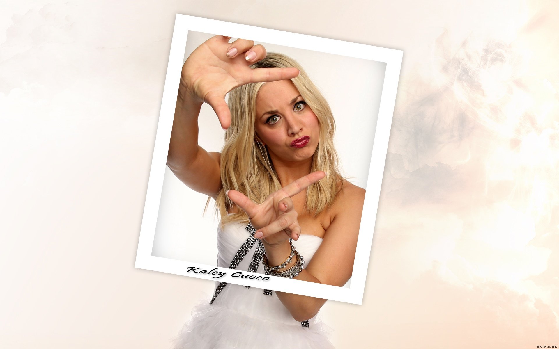 HD PC desktop wallpaper featuring celebrity Kaley Cuoco framed in a Polaroid-style border against a soft, neutral background.