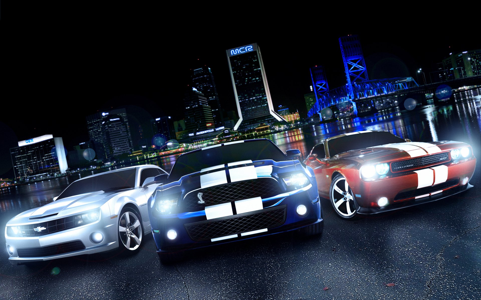 HD PC desktop wallpaper featuring three muscle cars parked on a wet road with a city skyline illuminated in the background at night.
