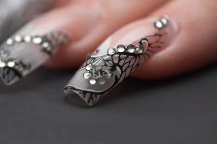Close-up of a woman's intricately designed nails with black patterns and rhinestones, captured in sharp detail for a 4K Ultra HD PC desktop wallpaper.