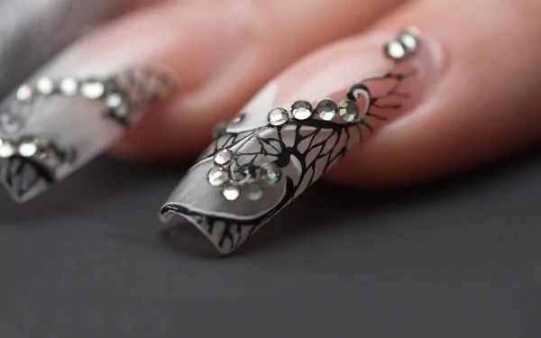 Close-up of a woman's intricately designed nails with black patterns and rhinestones, captured in sharp detail for a 4K Ultra HD PC desktop wallpaper.
