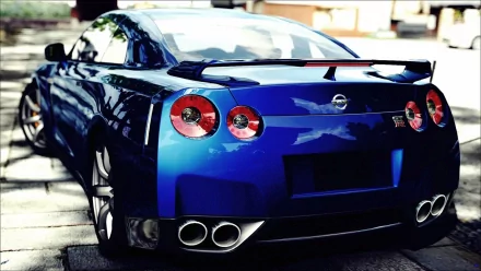 A stunning HD desktop wallpaper featuring a blue Nissan GT-R, showcasing its sleek design and powerful stance from a rear perspective.