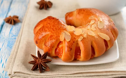 HD PC desktop wallpaper/background — food, baking: golden glazed braided almond pastry ring on a white plate with star anise on a blue wooden table