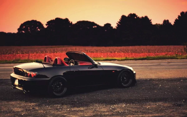 HD wallpaper of a Honda S2000 parked at sunset with a warm sky in the background.