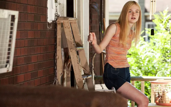 Elle Fanning poses on a porch, capturing a candid moment with a wooden ladder in the background. This HD image serves as a stylish desktop wallpaper.