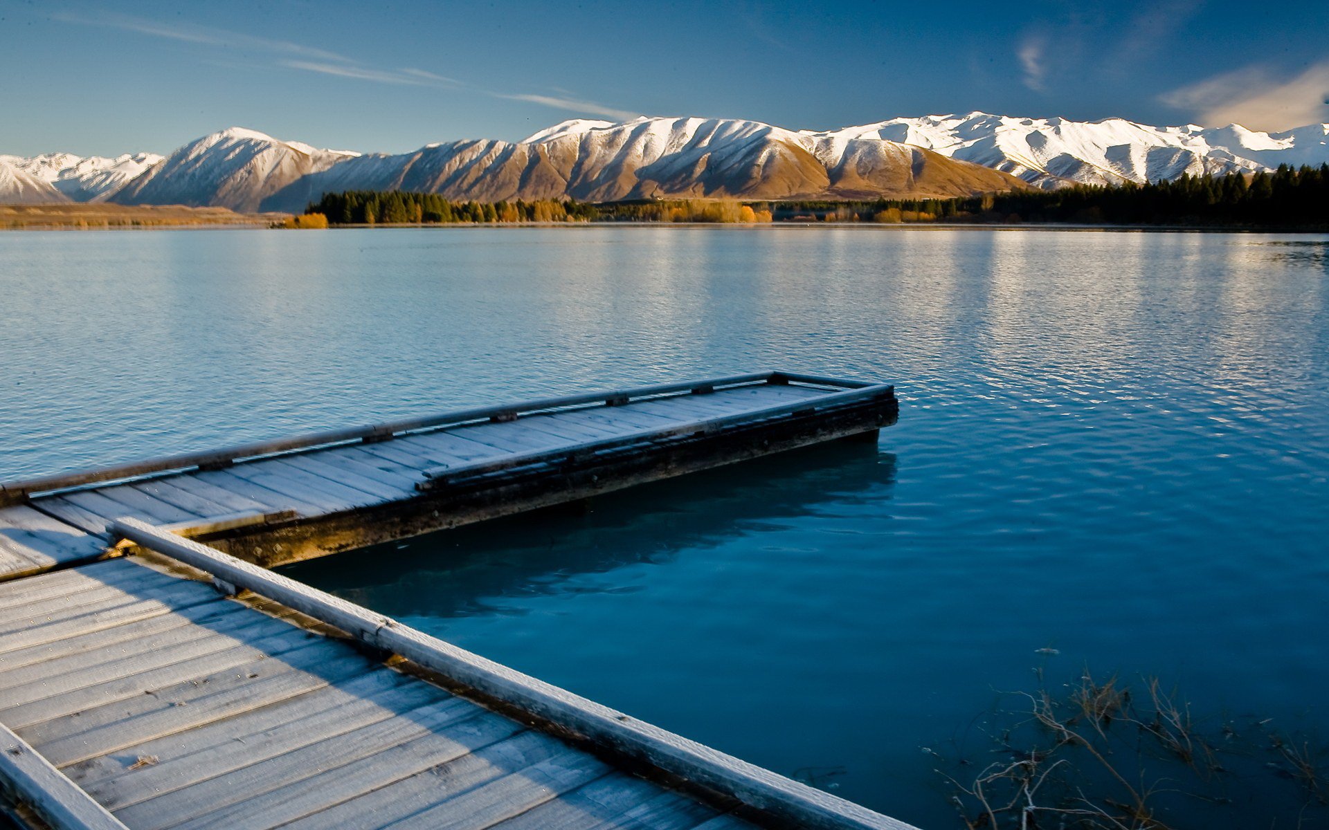 HD photography of a serene mountain lake with a wooden dock in the foreground and snow‑capped peaks across the water — PC desktop wallpaper and background.
